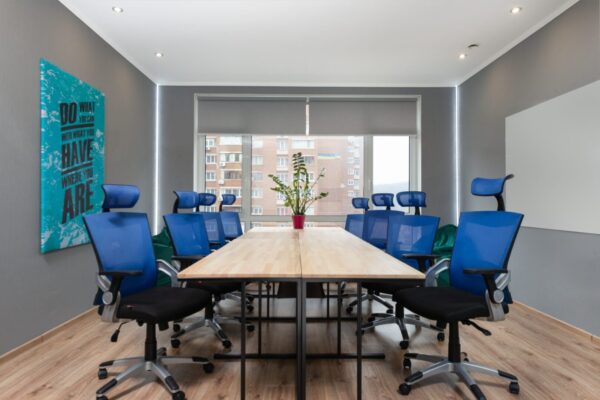 a classroom with blue office chairs around a long table